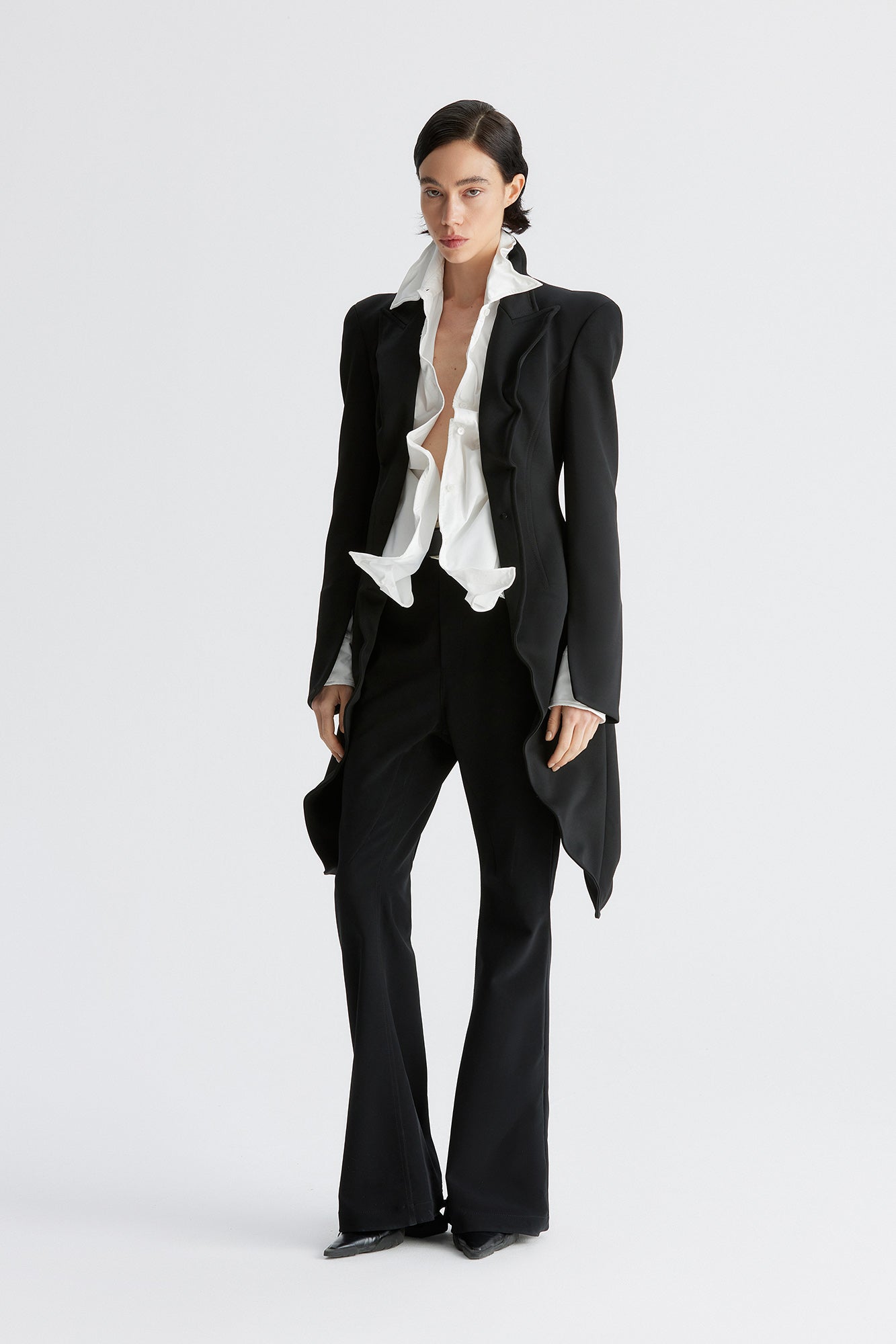 A round-shouldered suit with a swallow-tail hem