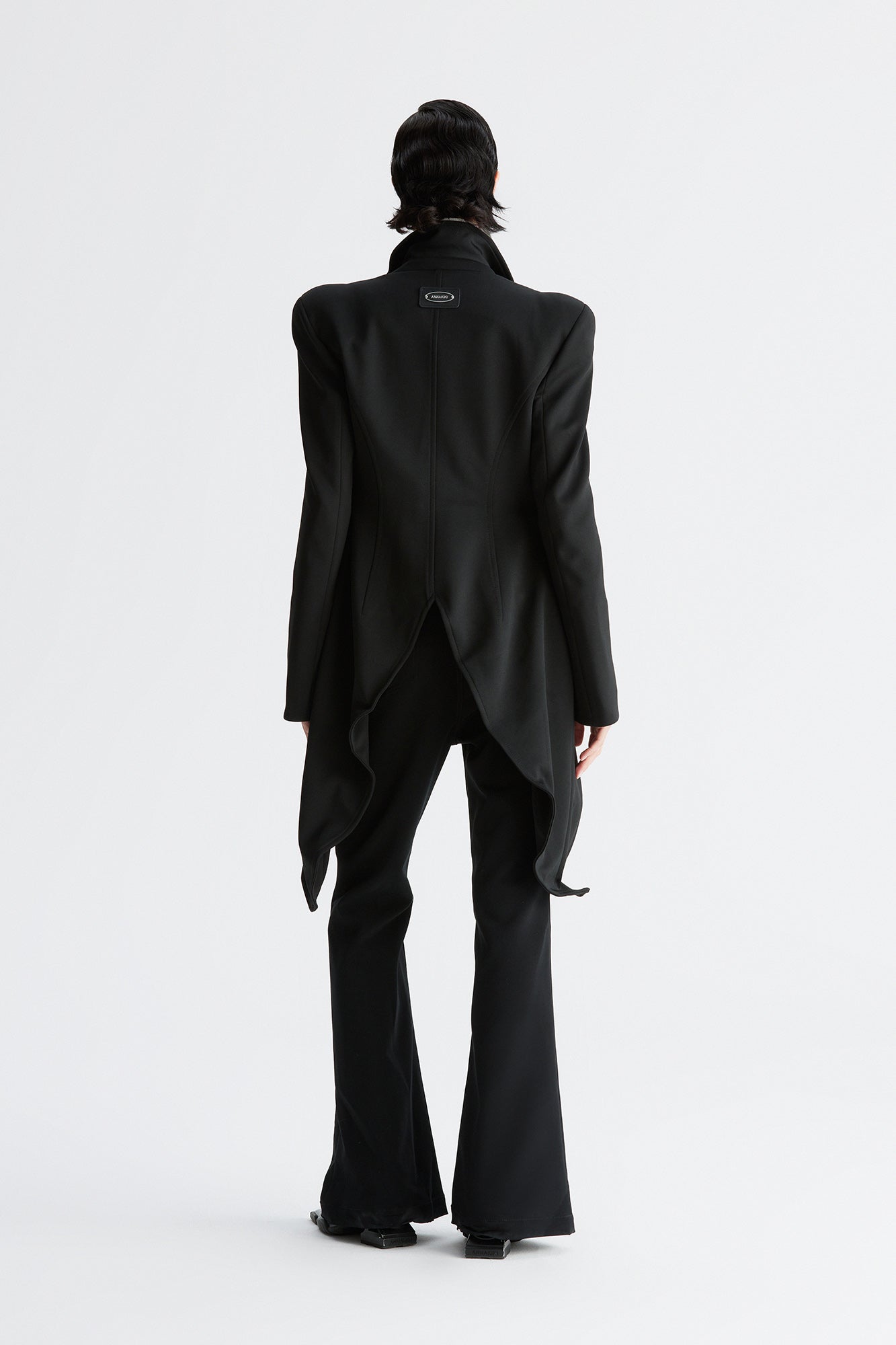 A round-shouldered suit with a swallow-tail hem