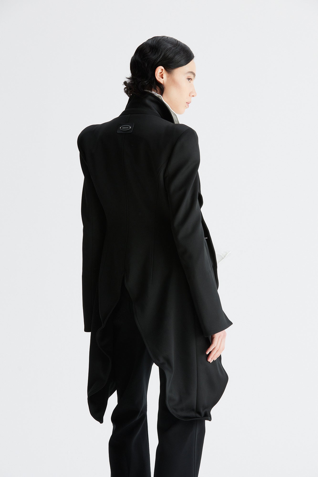 A round-shouldered suit with a swallow-tail hem